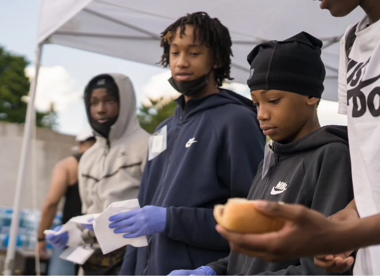 Good Guide Ambassadors serving food at a community barbecue in Scarborough